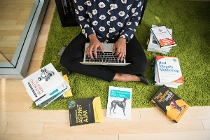 Woman on laptop with tech books