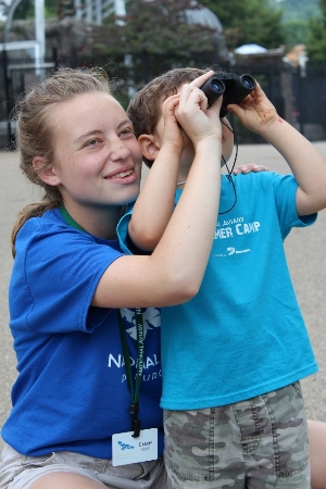 Teen volunteer helps child at camp