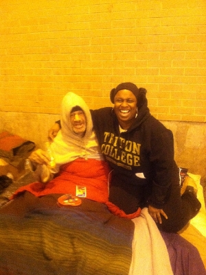 Shelia sharing a hug and laugh with a homeless man.