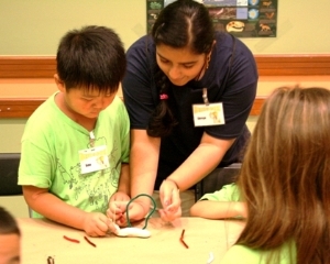 Volunteer assisting a student with a craft