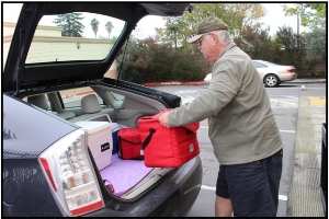 A generous volunteer packing meals into his car.