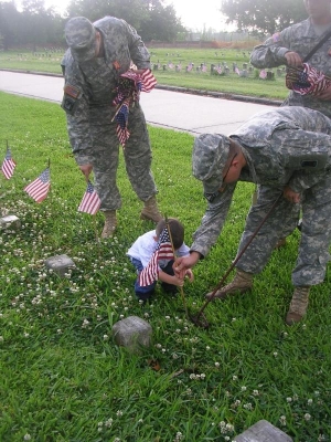 Military placing flags on headstones