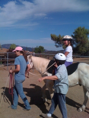 Volunteer leads pony for handicapped child