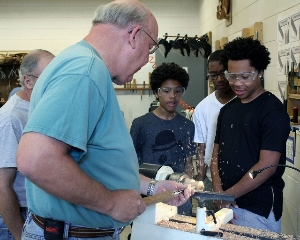 Volunteers teach students woodturning