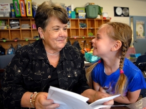 Foster Grandparent Nancy reads to girls at school