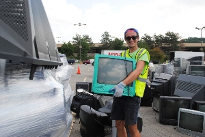 A volunteer collects a TV to be responsibly recycled.