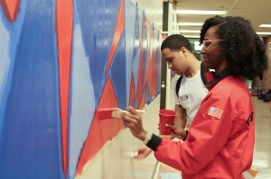 City Year Corps Members painting a school mural