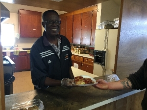 One of our regular volunteers serving lunch.