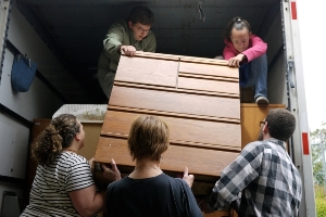 Volunteers help to deliver dressers to new homes.