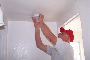 Volunteer installing Smoke Alarm