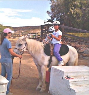 Volunteer leads pony for handicapped child