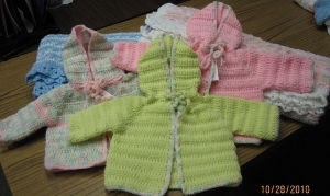 Baby jackets hand-crocheted by senior volunteers.